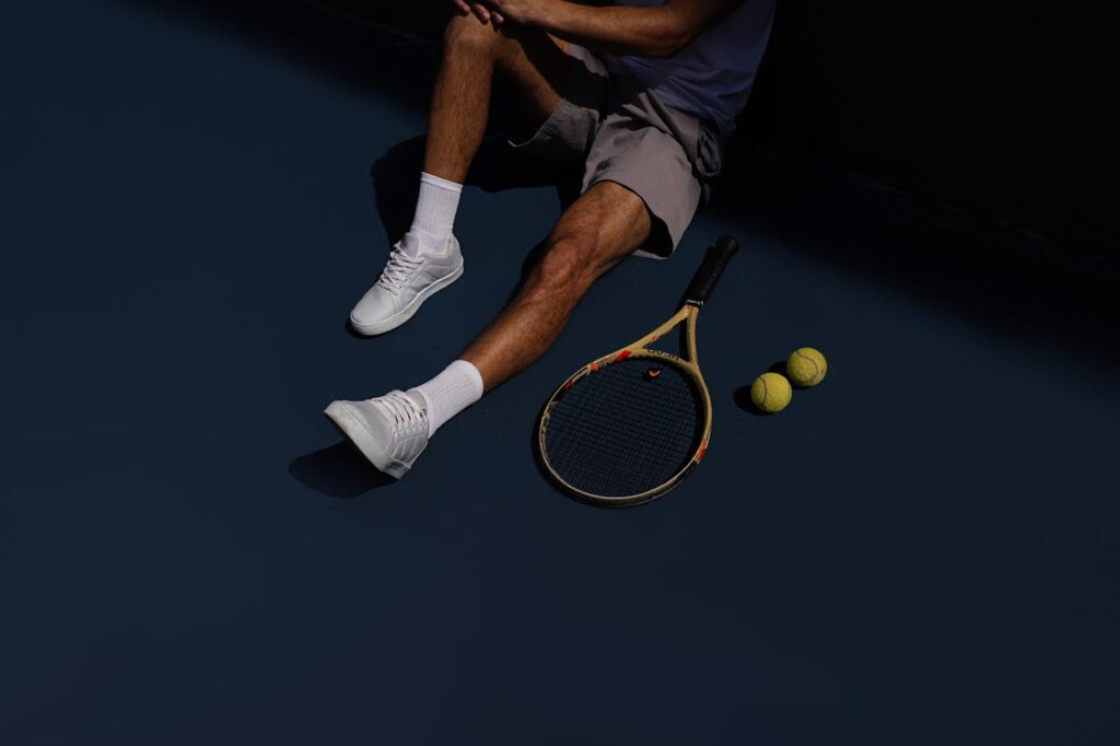 A Tennis Player Resting on the Ground